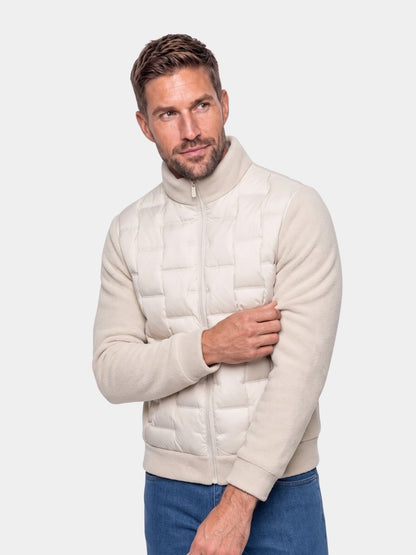 Man wearing cream quilted jacket with knit sleeves Cross & Crown