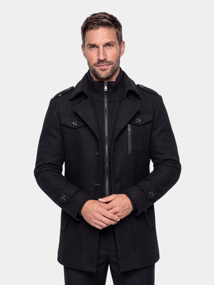 Man wearing the black layered two-piece coat zipped to the knit collar