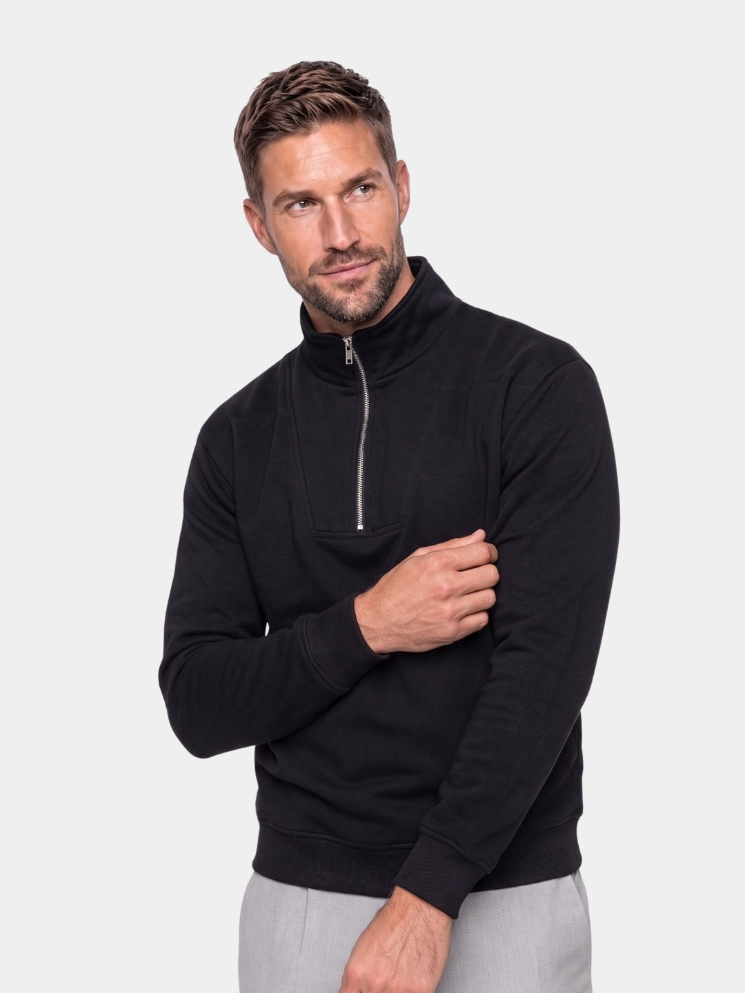 Cross & Crown man wearing a black ribbed quarter-zip sweatshirt