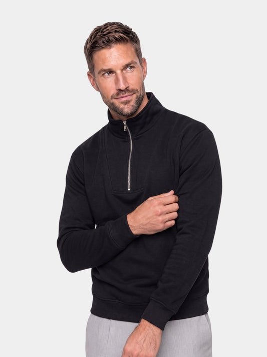 Cross & Crown man wearing a black ribbed quarter-zip sweatshirt
