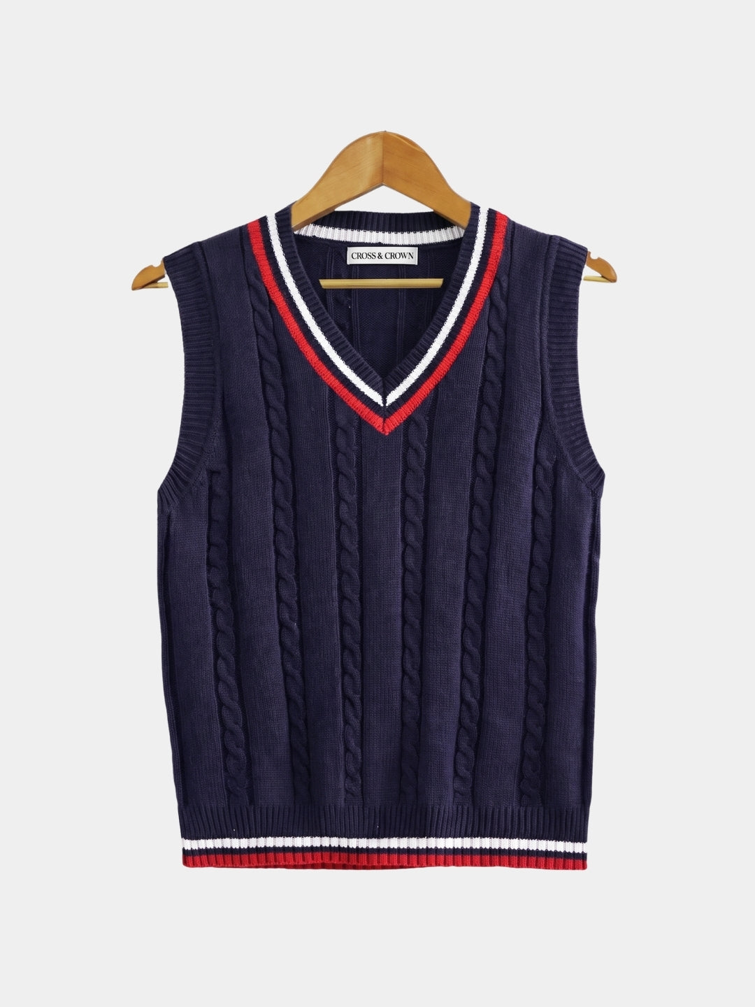 Front view of the navy cable-knit cricket vest with red trim.