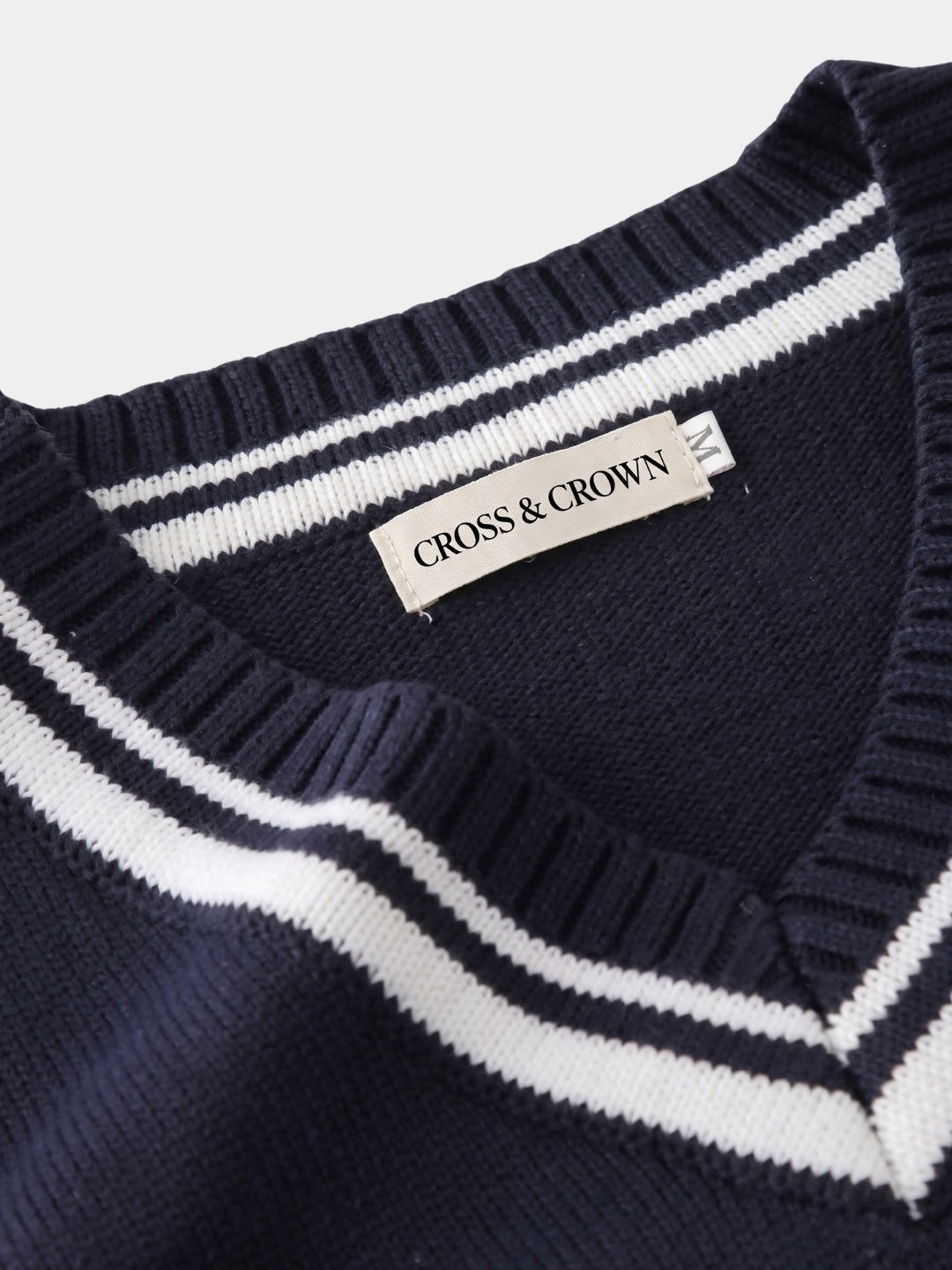 Close-up of the striped V-neck trim and brand label.