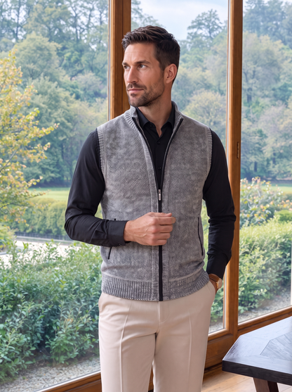 Gray full-zip sweater vest worn with a black shirt and cream trousers