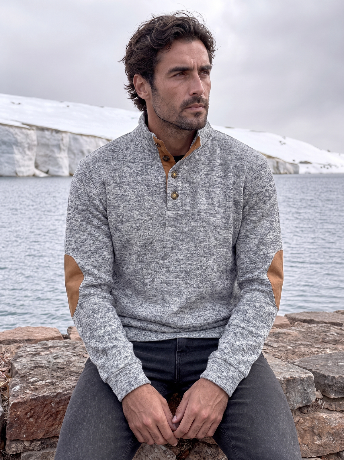 Man wearing the heathered gray pullover near the coast