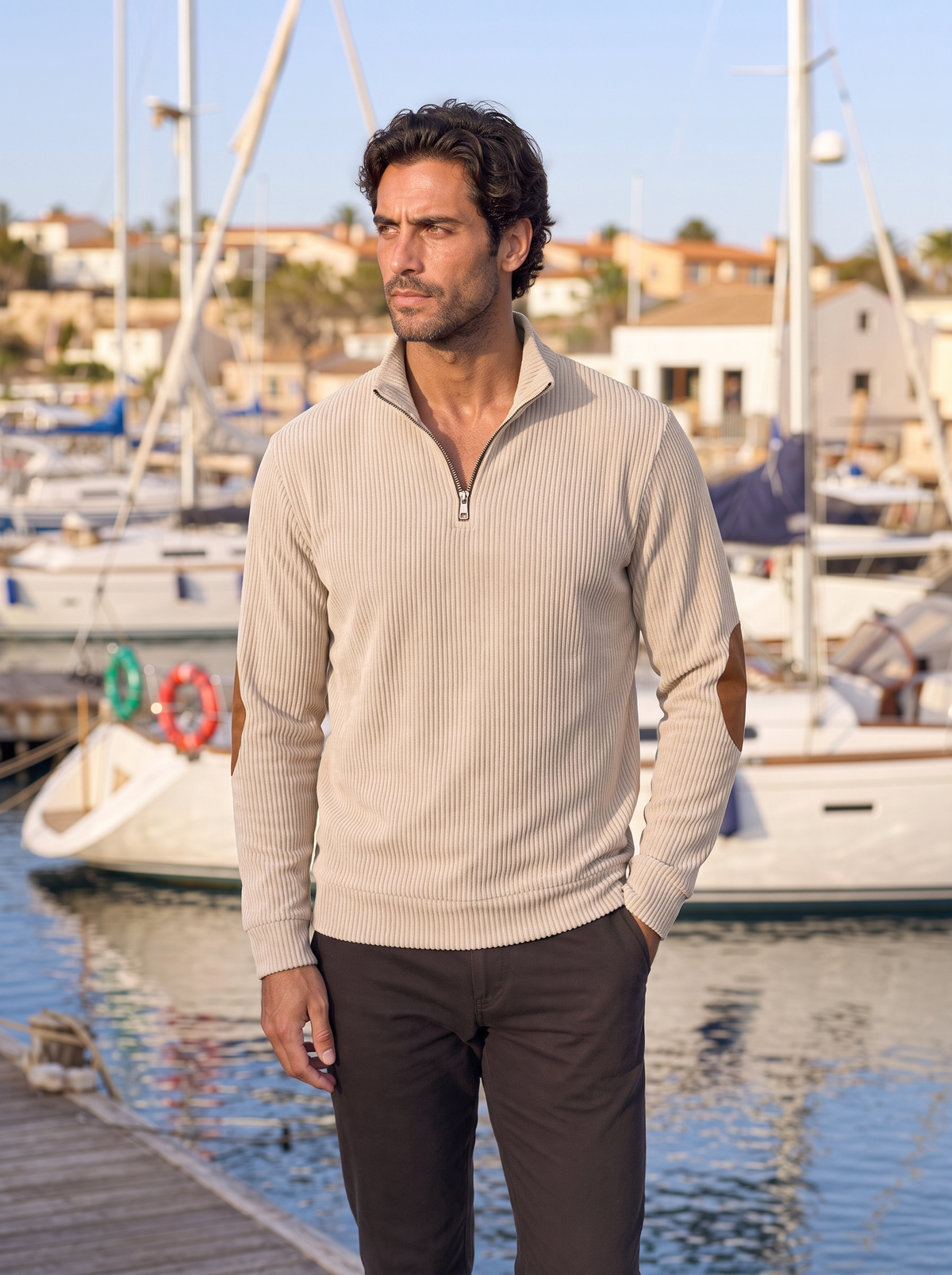 Man styled in the beige corduroy pullover near a marina