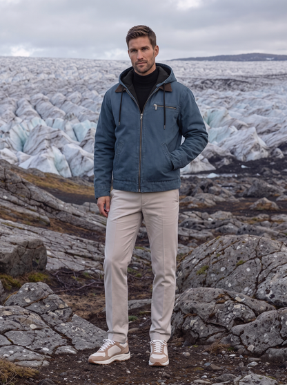 Man standing on rocky terrain wearing the blue hooded work jacket