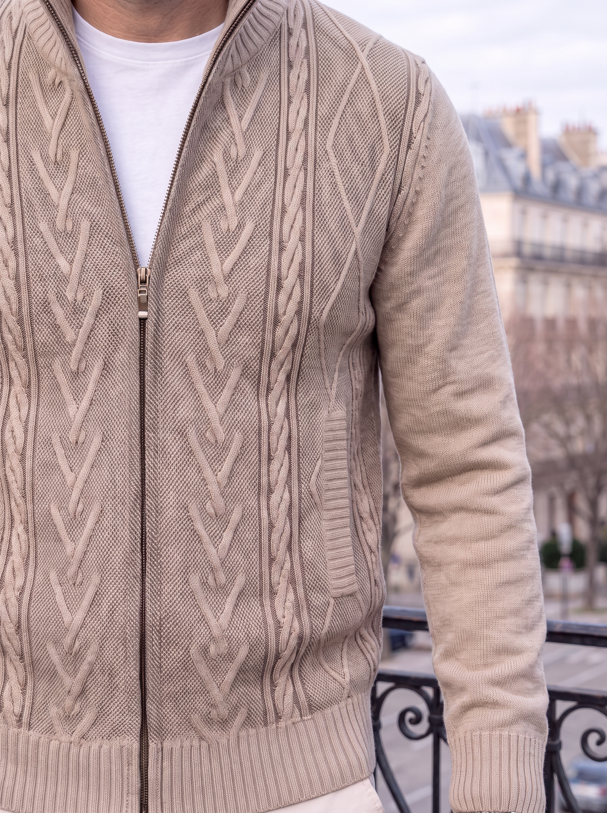 Close-up of the beige cable-knit cardigan collar and zip